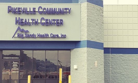 Pikeville Community Health Center sign on a light green building with blue trim and glass doors