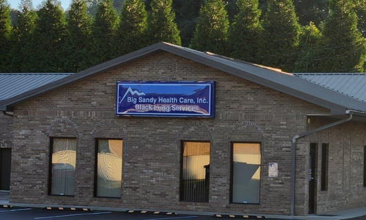 Brick building with a sign for a health care and rehab center above the entrance.