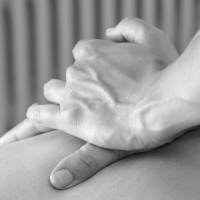 Main appliquant une pression pendant un massage. Photo en noir et blanc.