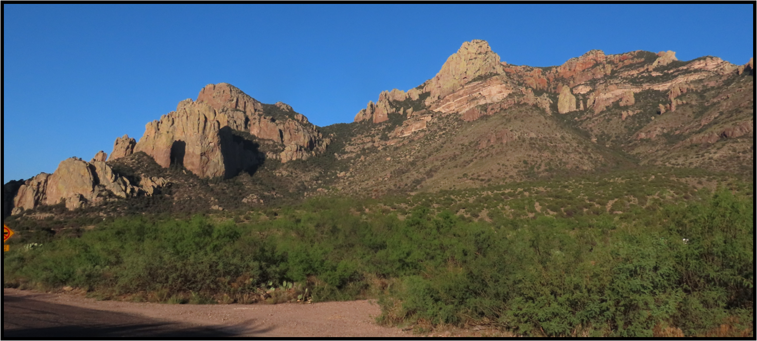 A mountain range with a dirt road in the foreground