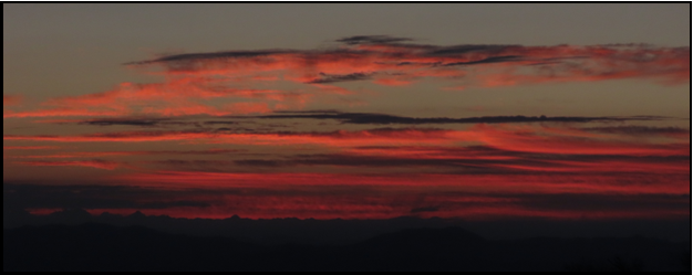 A picture of a sunset with red clouds in the sky
