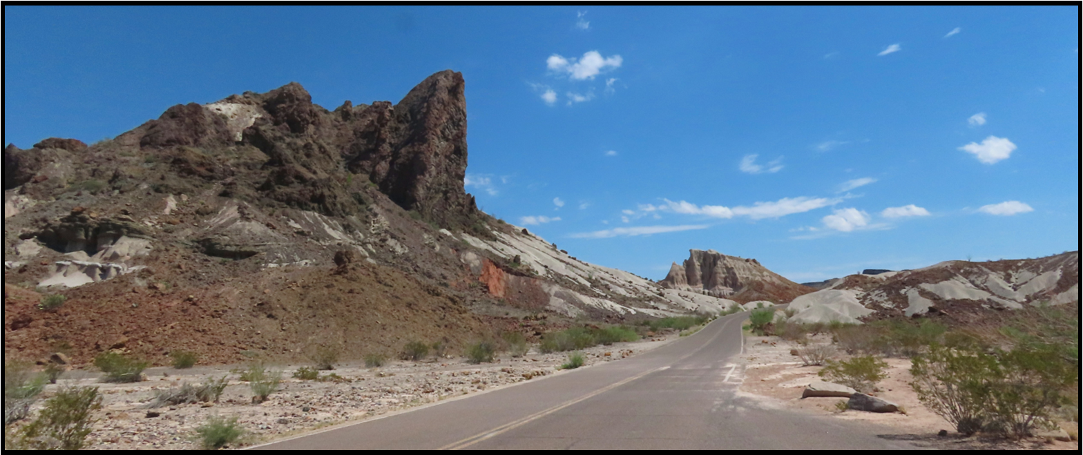 A road in the desert with mountains in the background