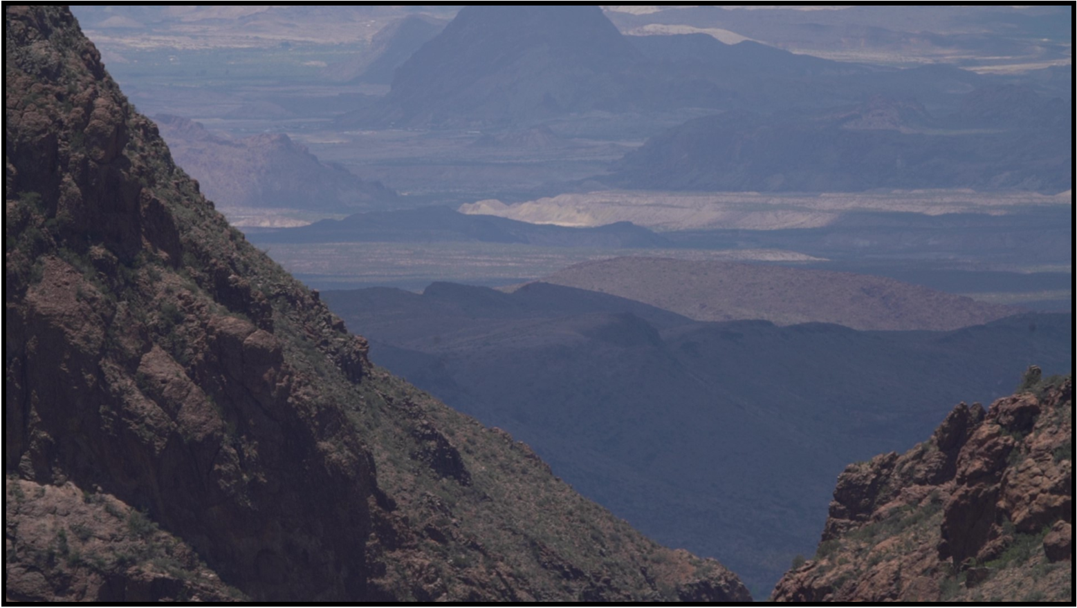A view of a mountain valley with mountains in the background