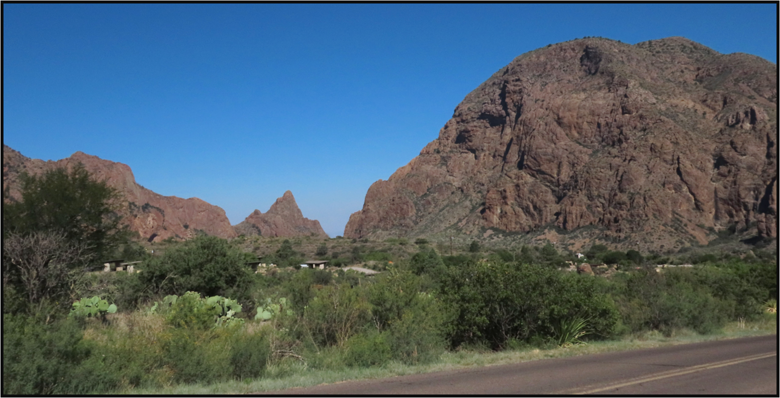 A road going through a desert with mountains in the background
