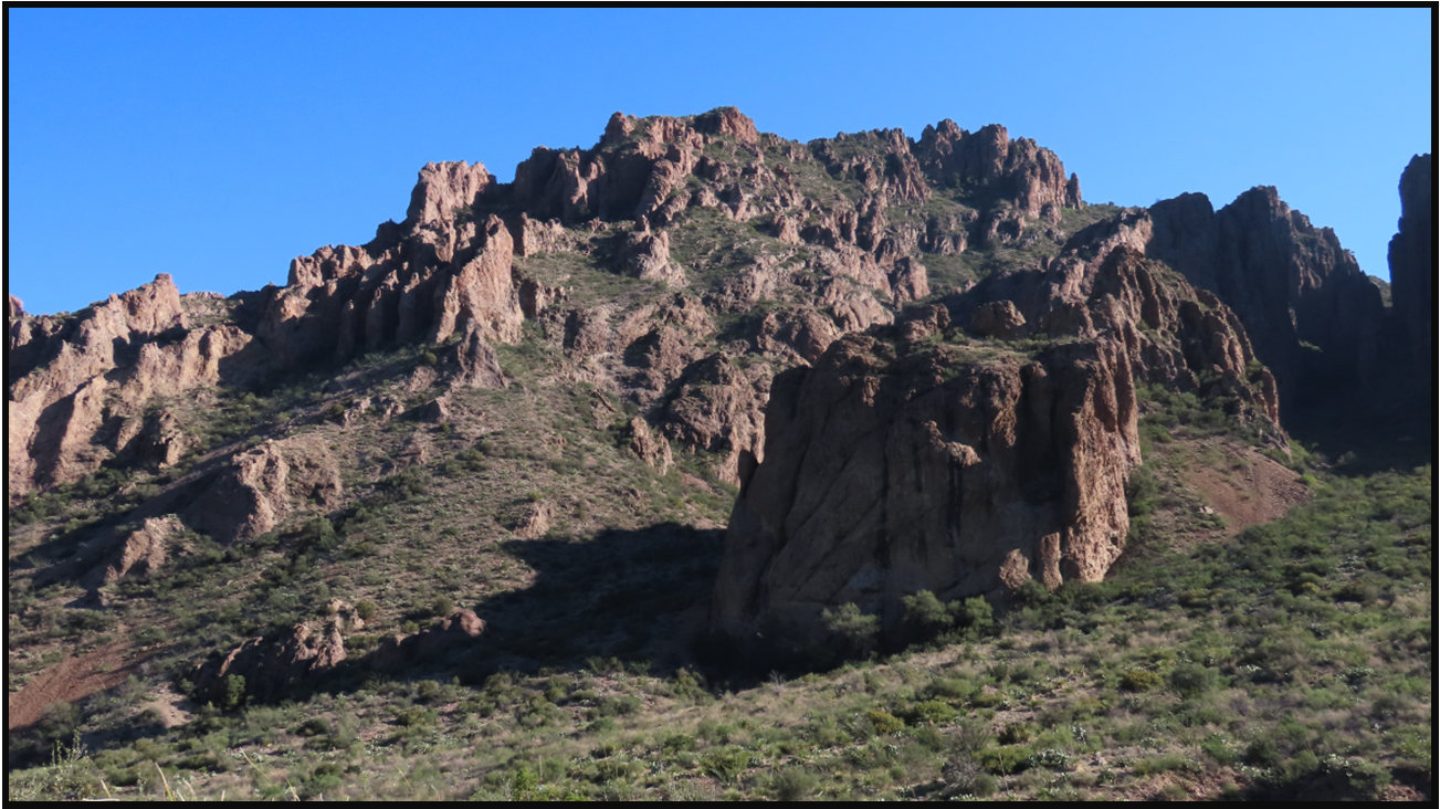 A mountain with a blue sky in the background