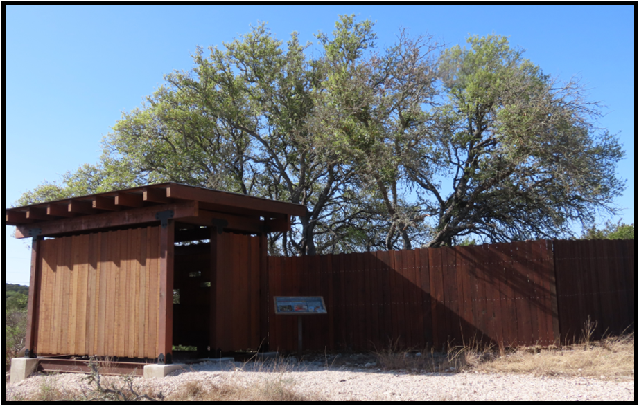 A wooden shelter with a sign in front of it