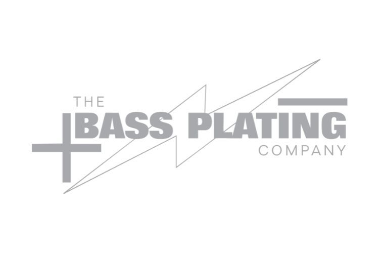 Logo for The Bass Plating Company, featuring gray text and a lightning bolt design with a plus and minus symbol.