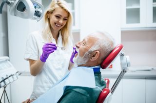 Dental Implants — Dentist Checking Patient's Teeth in Pittsburgh, PA