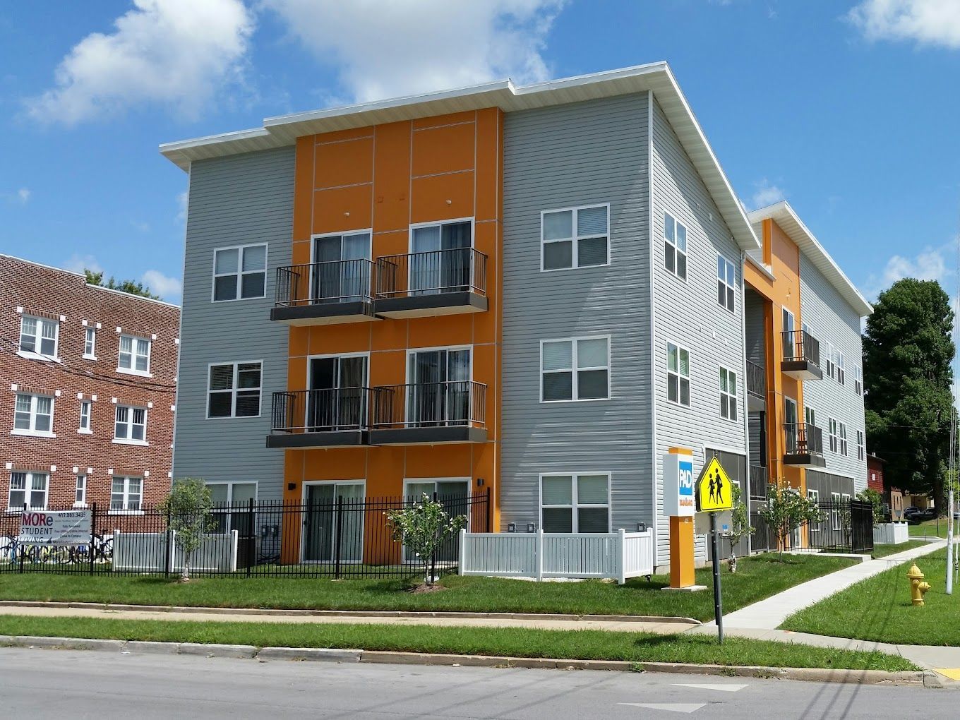A large apartment building with a yellow pedestrian crossing sign in front of it
