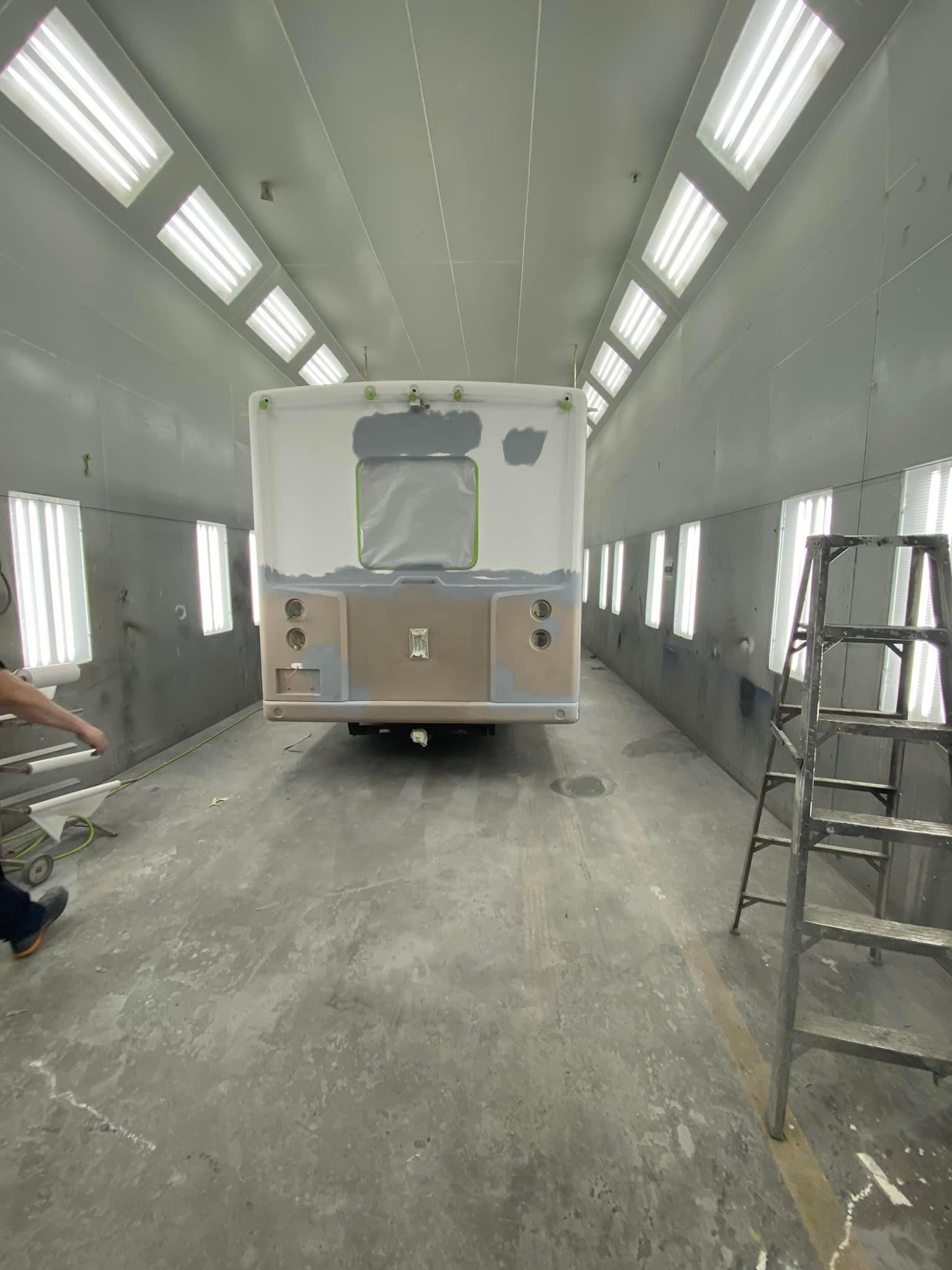 Un camion est peint dans une cabine de peinture.