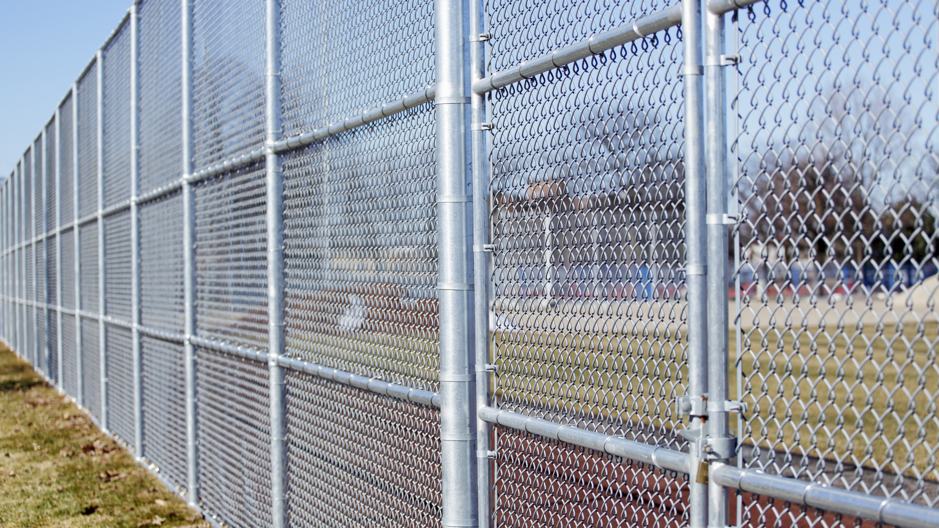 A chain link fence is surrounding a baseball field.