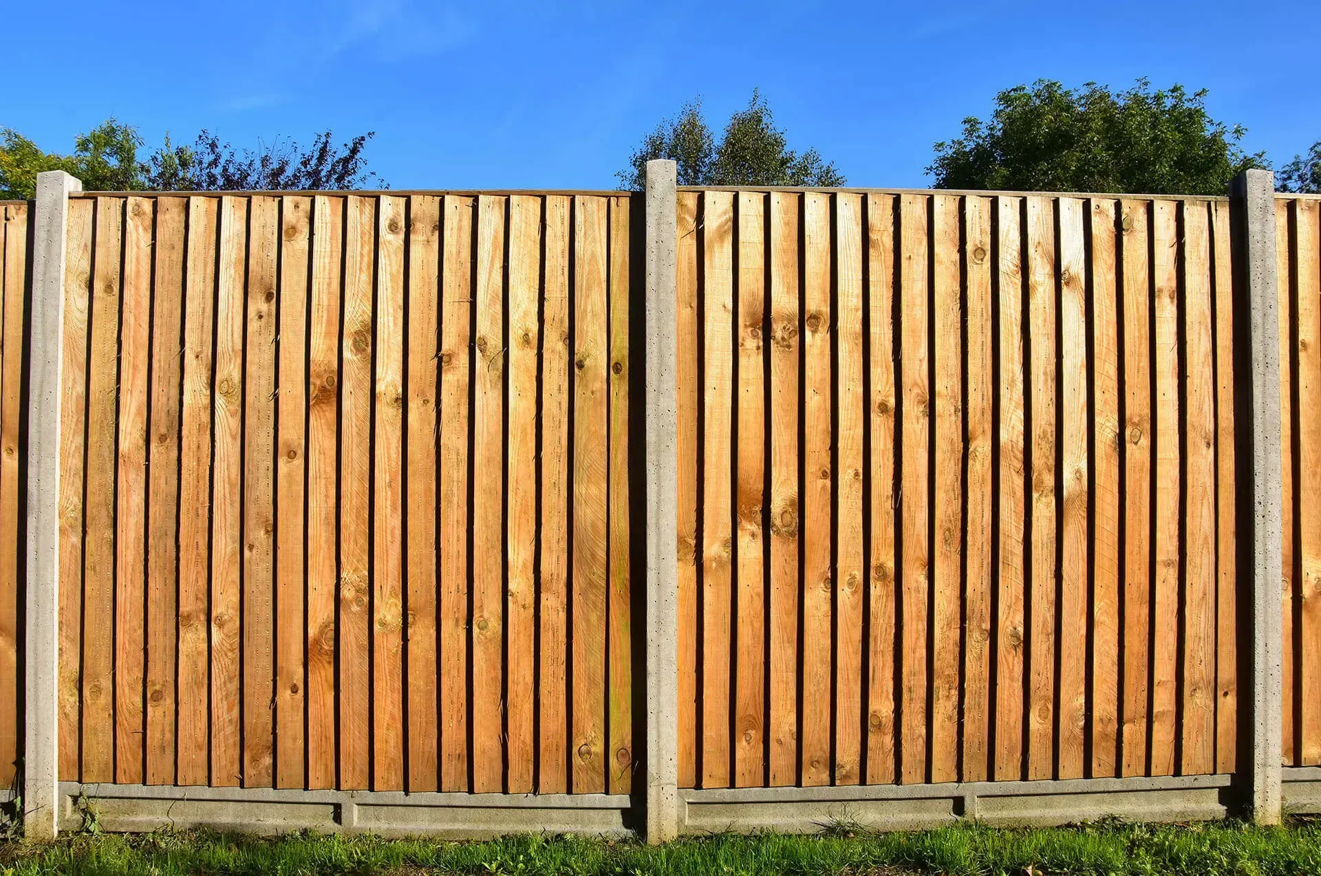 A wooden fence with a blue sky in the background.