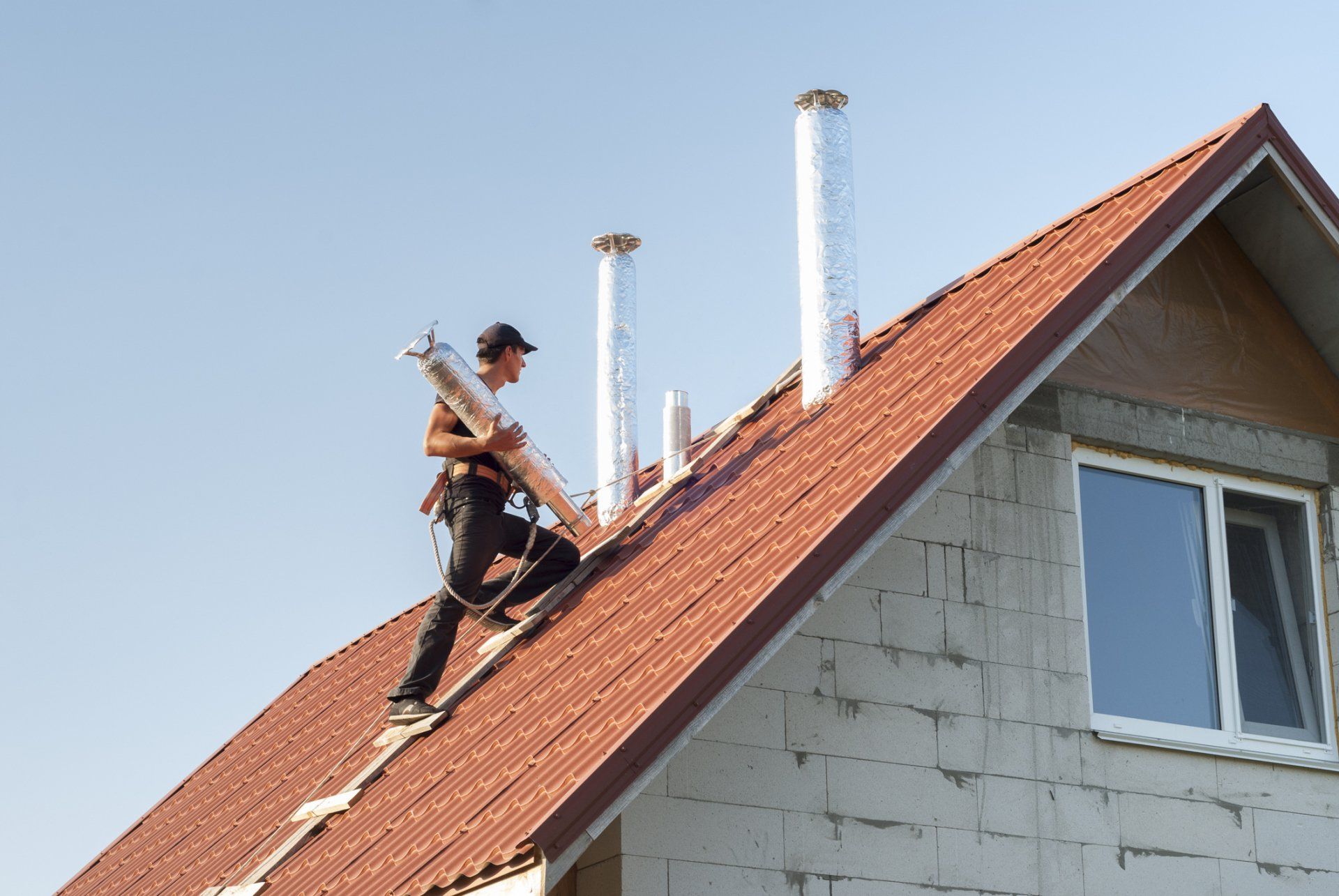 Chimney Repairs — Man Climbing On A Roof To Repair A Chimney in Pittsburgh, PA
