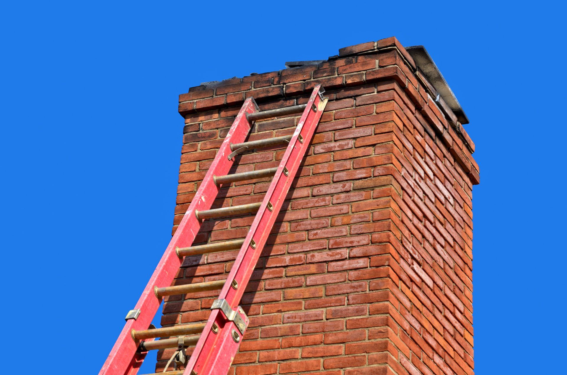 Storm Damage Repairs — A Ladder On A Chimney Made Of Bricks in Pittsburgh, PA