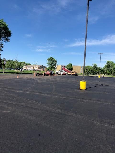 A parking lot with a yellow pole in the middle