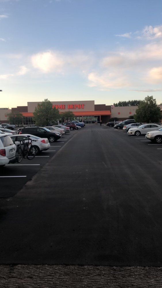 A lot of cars are parked in a parking lot in front of a home depot.
