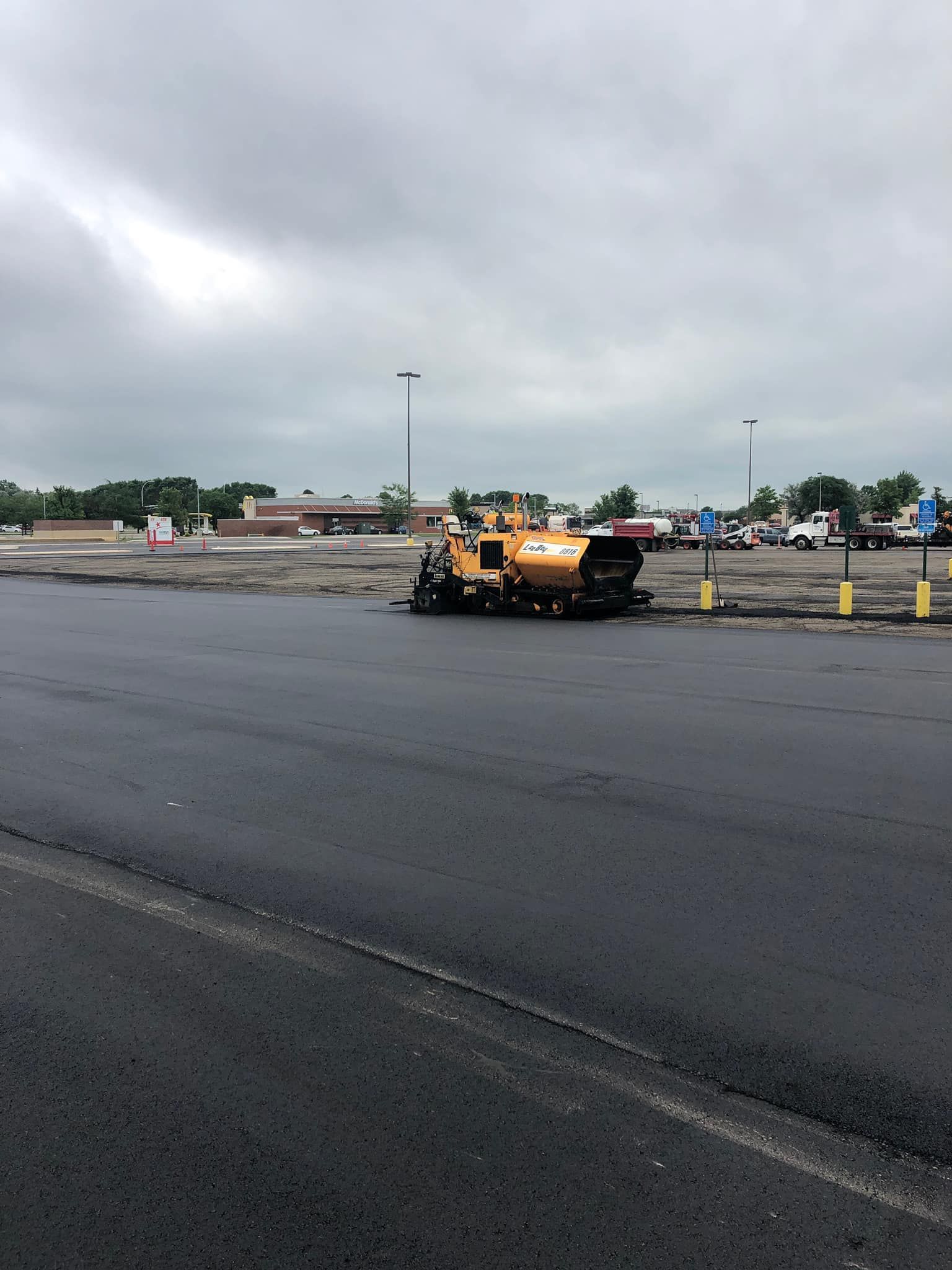 A yellow truck is sitting in the middle of a parking lot.