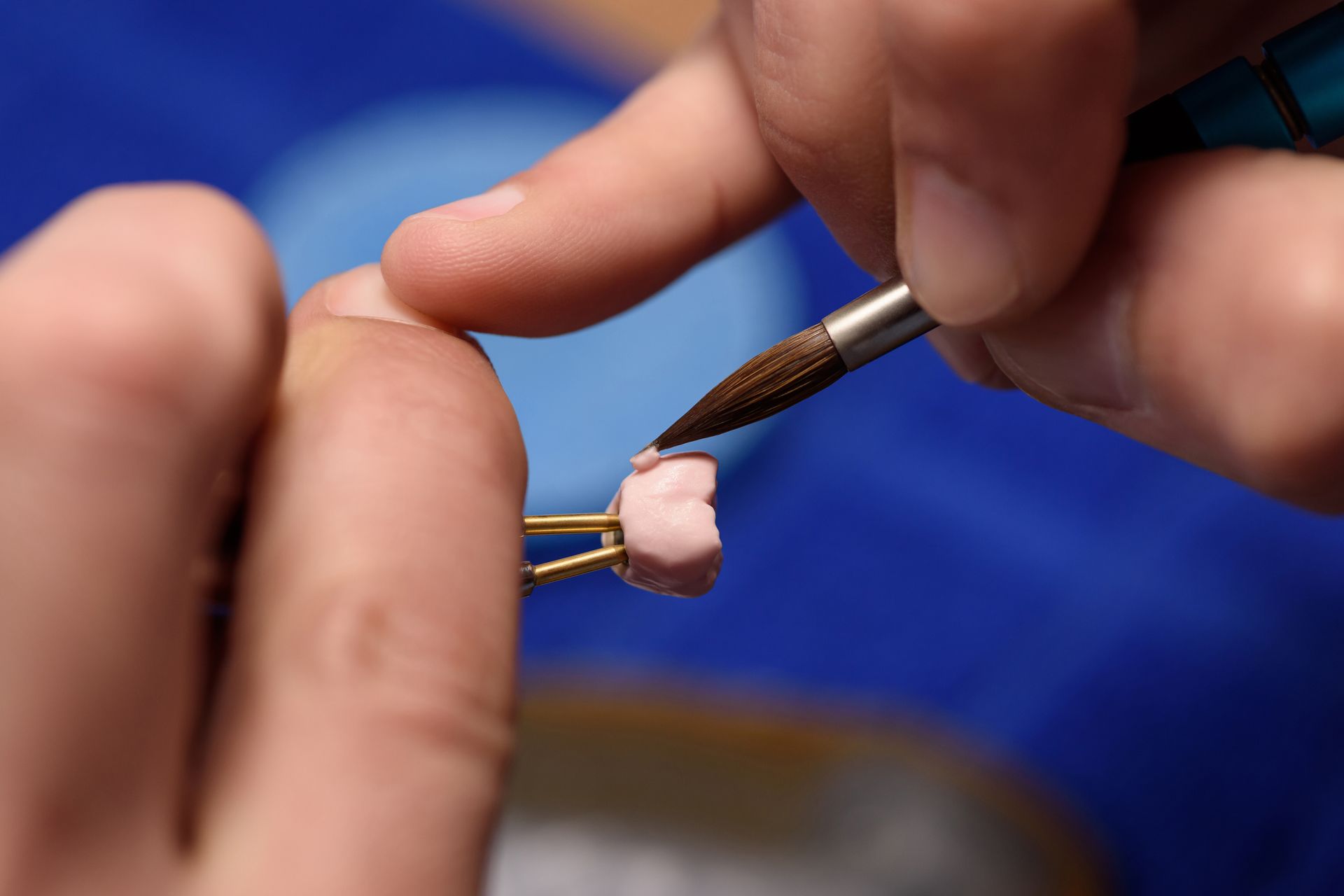 Dentist examining a patient's teeth with tools, the patient wearing protective glasses, indoor setting.
