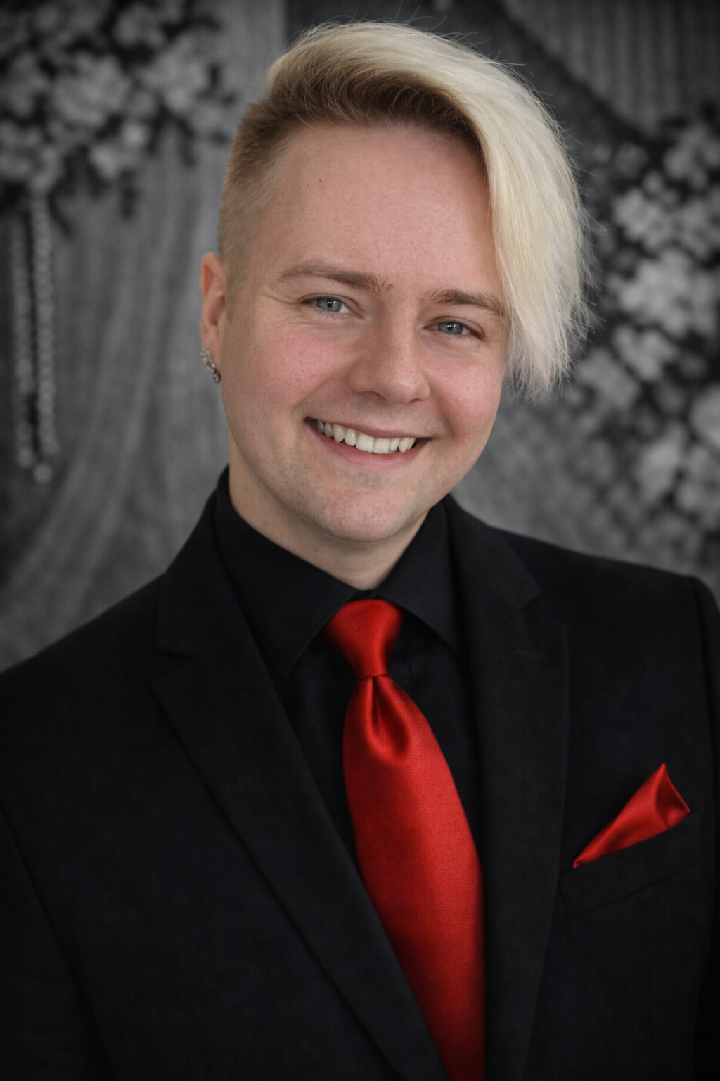 A man wearing a vest and tie is smiling for the camera.