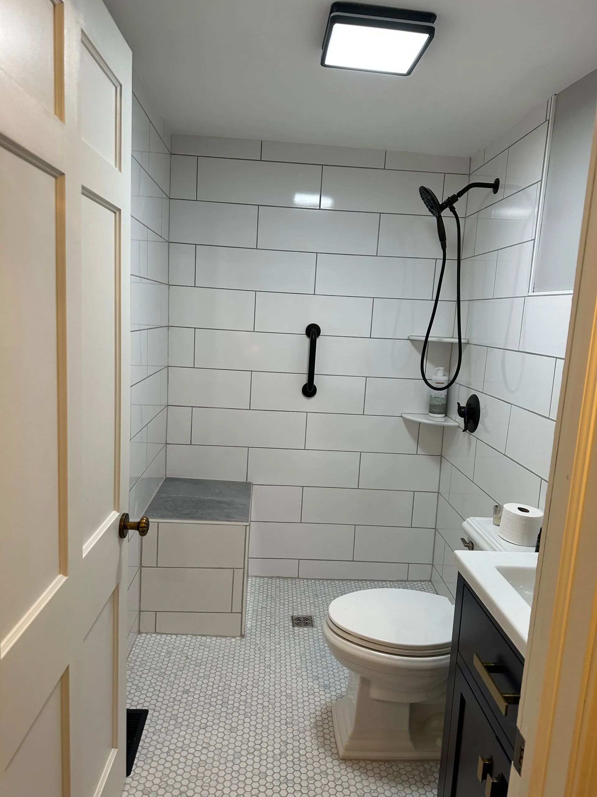 A bathroom with a toilet , sink and shower.
