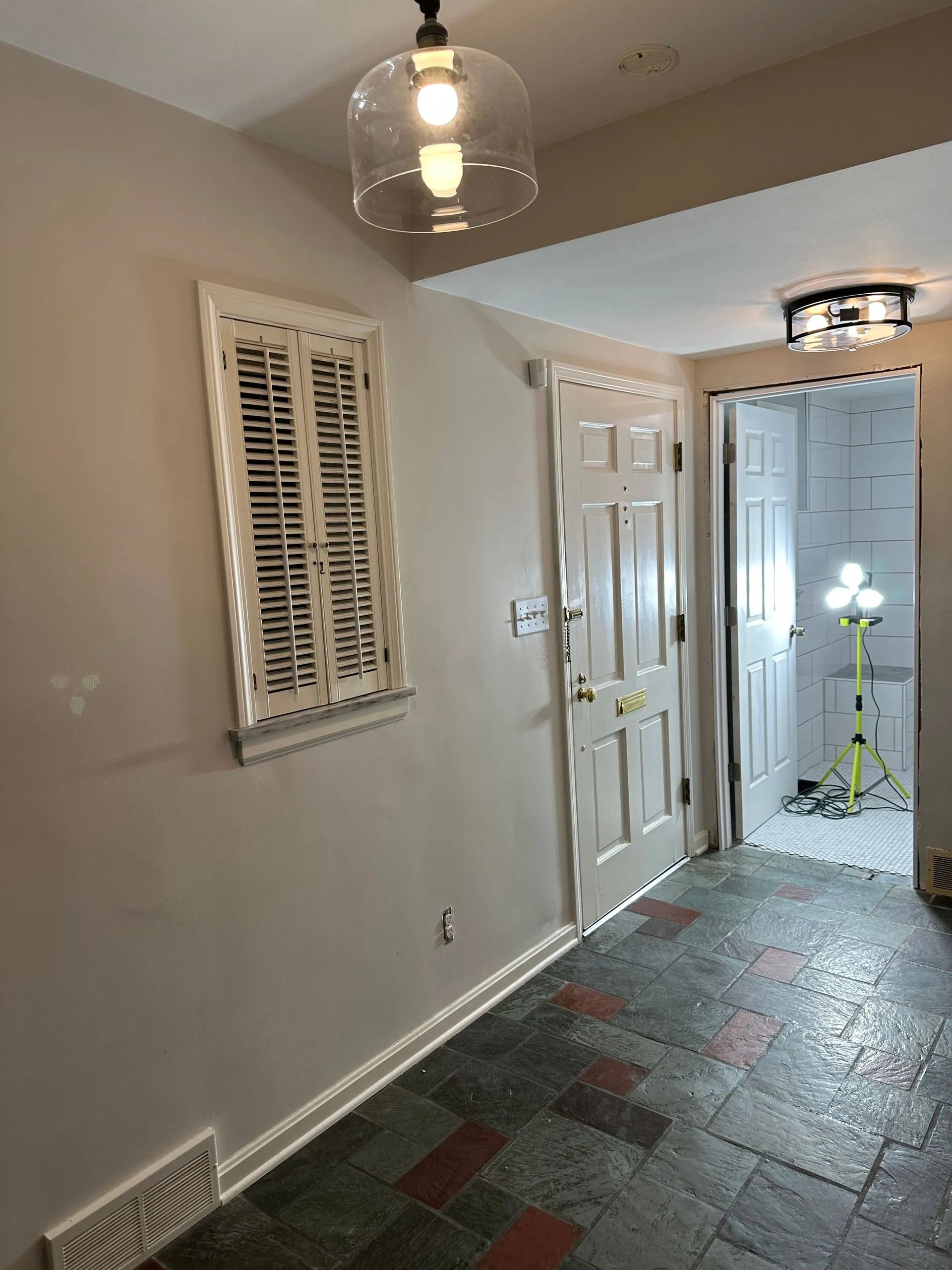 A hallway with a window and a light hanging from the ceiling
