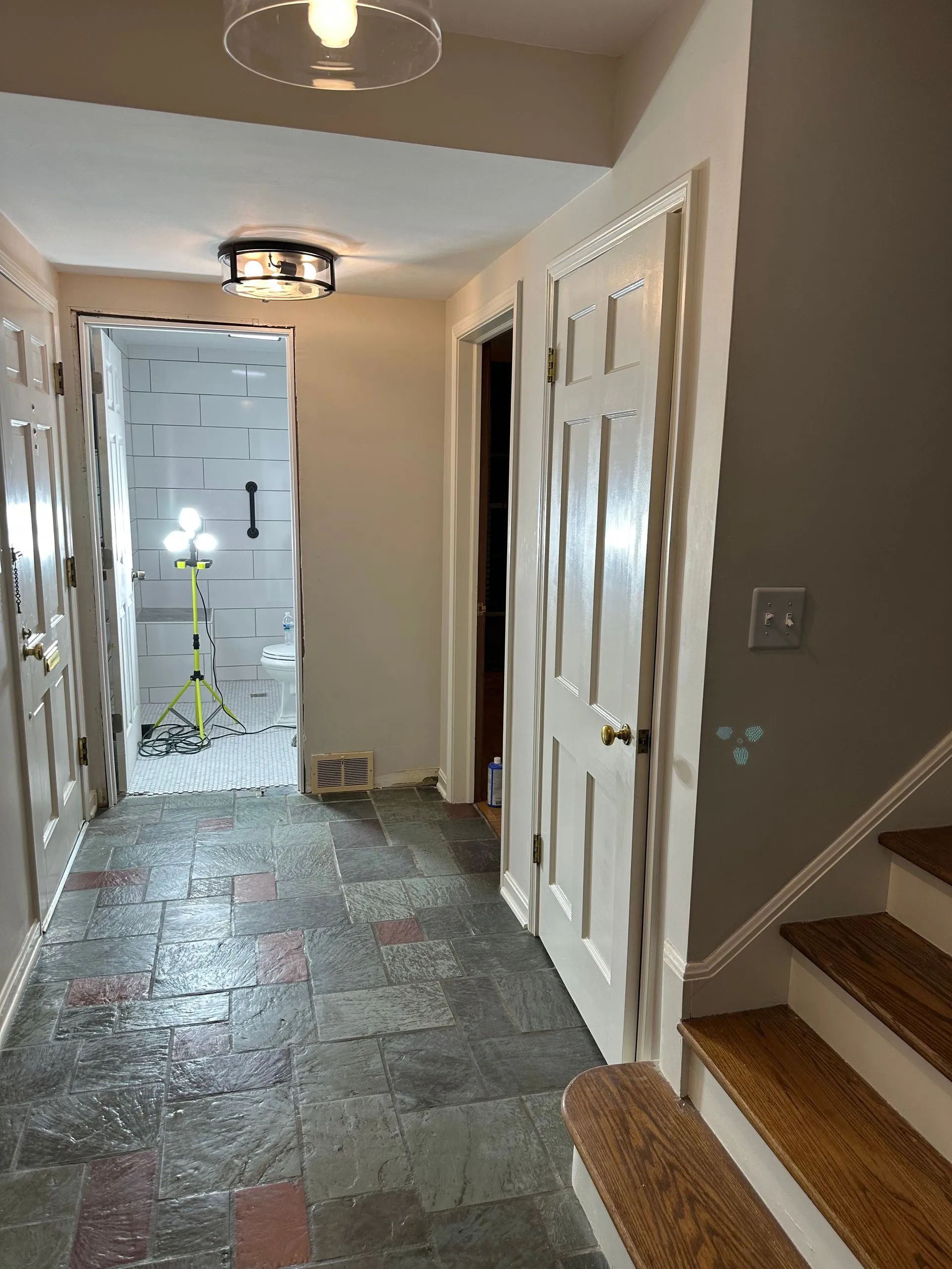 A hallway with stairs and a light on the ceiling