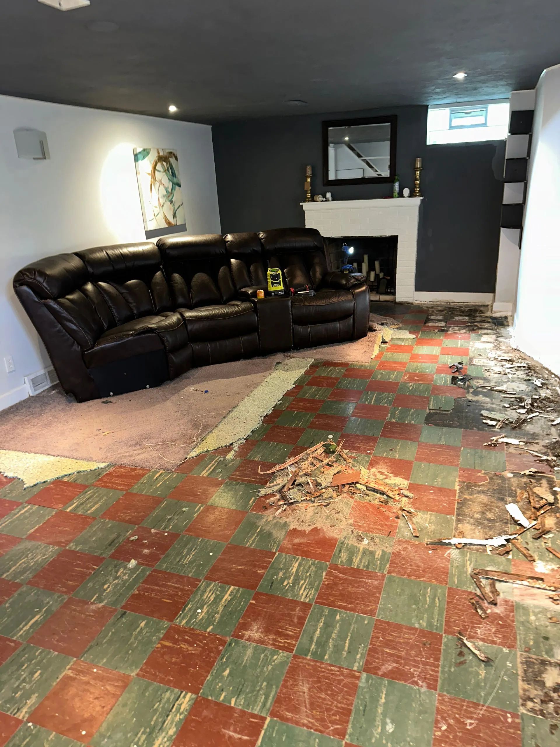 A living room with a couch , fireplace and checkered floor.