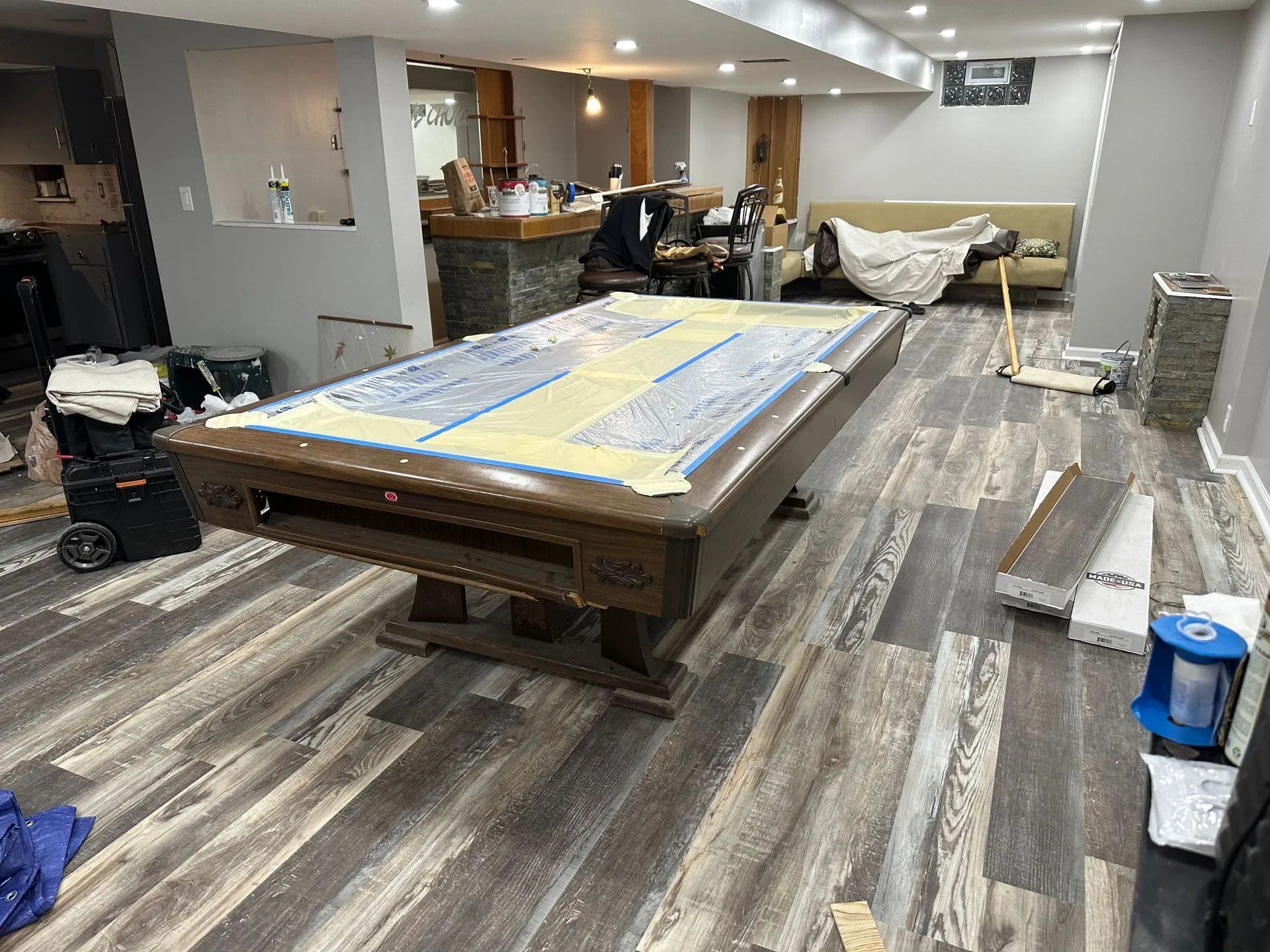 A pool table is sitting in a room with a wooden floor.
