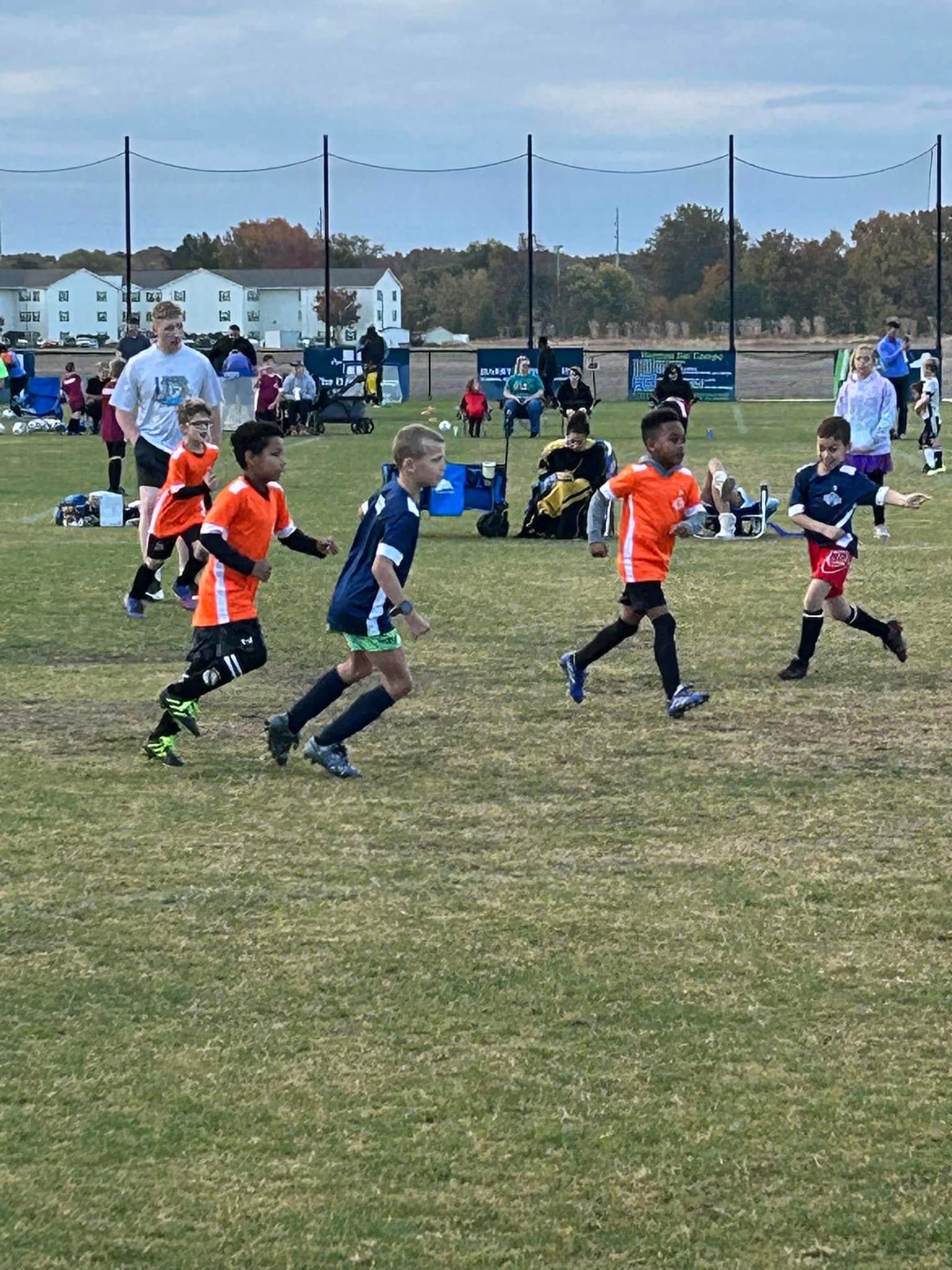 A group of young boys are playing soccer on a field.