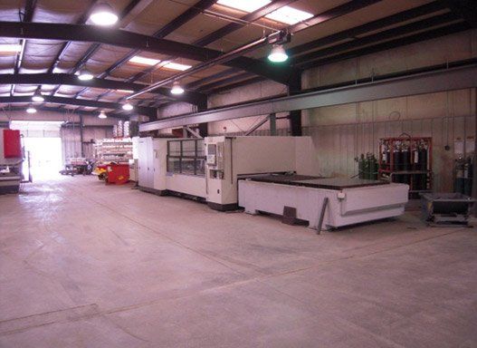 Large industrial workshop with machinery and overhead lighting.