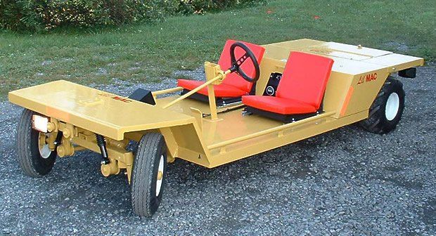 Yellow industrial cart with red seats, outdoors.