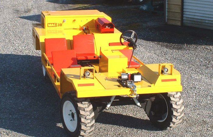 Yellow utility vehicle with red accents and off-road tires, viewed outdoors.