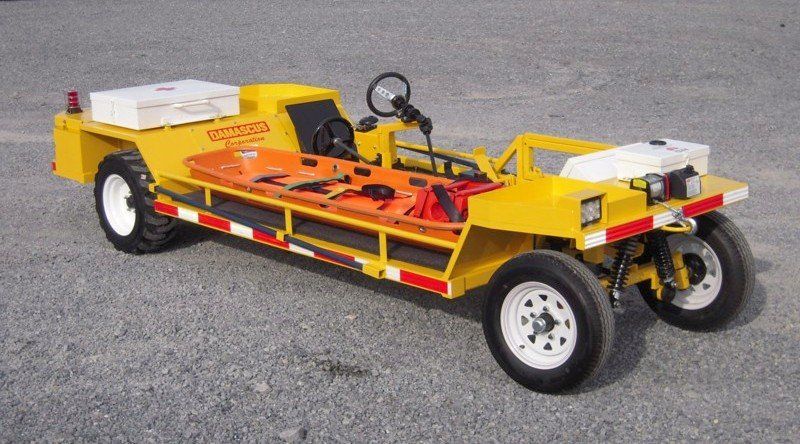 Yellow medical transport vehicle with stretcher, white wheels, and storage.