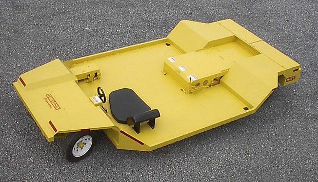 Yellow, ride-on mower with black seat and white wheel, on asphalt.