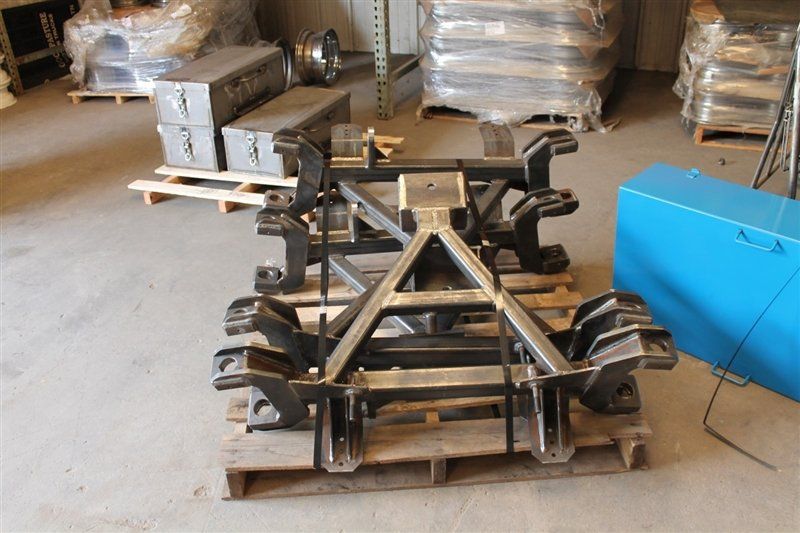 Metal industrial frame on a pallet in a warehouse, with other equipment in the background.
