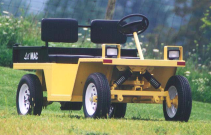 Yellow Lil Mac utility vehicle with black seat backs and headlights, parked on grass.