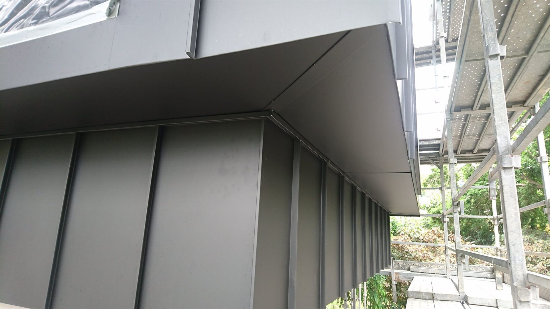 Wall Cladding in Angle Standing Seam System in Matt Black Prefa Aluminium Soffit in Sluss Seam System
