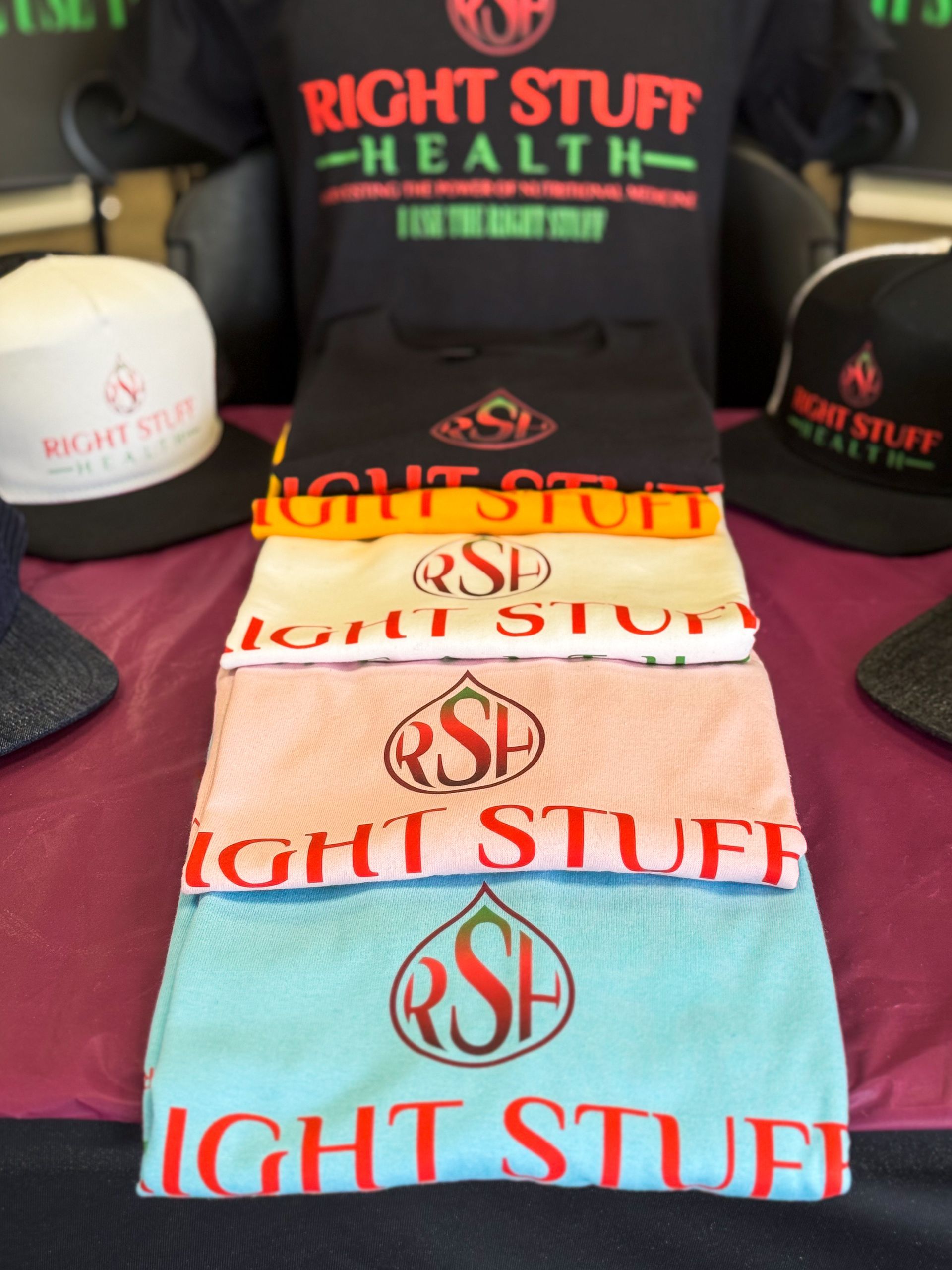 A stack of right stuff health shirts and hats