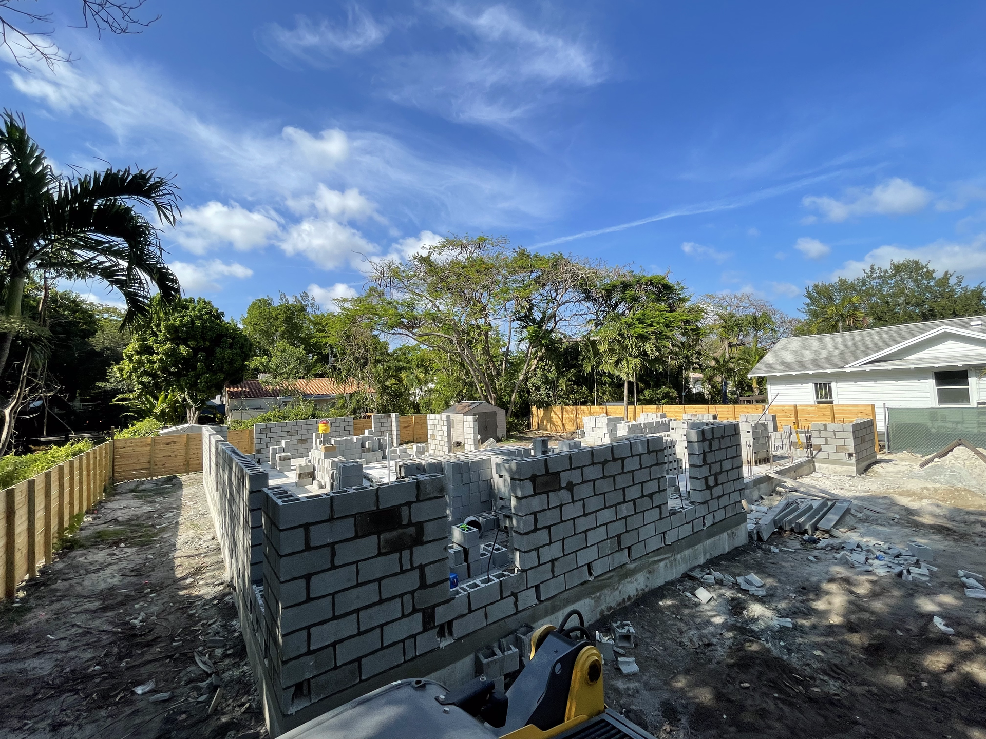 Construction site with concrete block walls under blue sky.