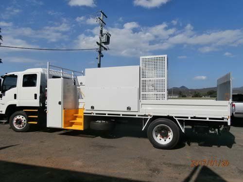 white workman truck with yellow stairs and caging