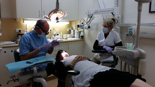 A Woman is Laying in a Dental Chair While a Dentist Examines Her Teeth — Advanced Dental Southern Highlands in Moss Vale, NSW