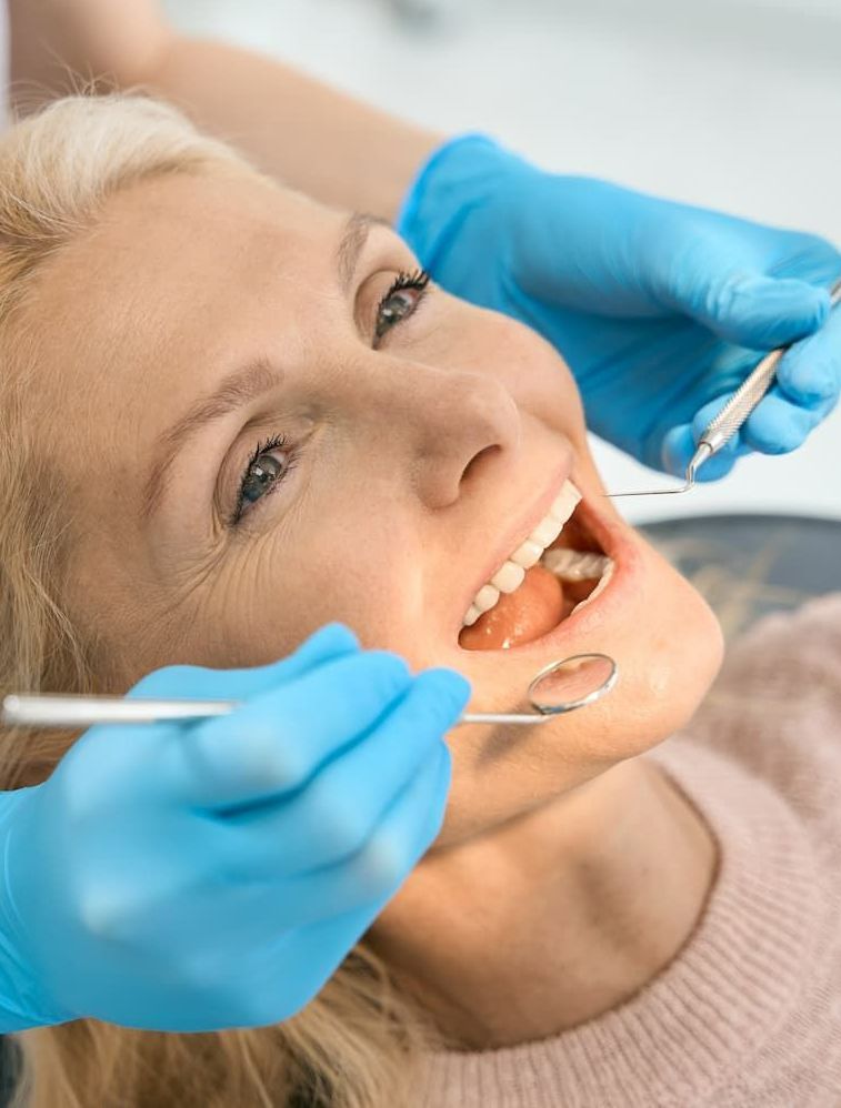 A Woman is Having Her Teeth Examined by a Dentist — Advanced Dental Southern Highlands in Moss Vale, NSW