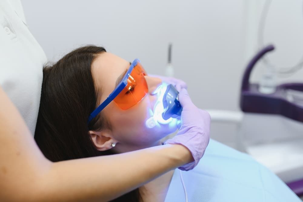 A Woman is Getting Her Teeth Whitened by a Dentist — Advanced Dental Southern Highlands in Moss Vale, NSW