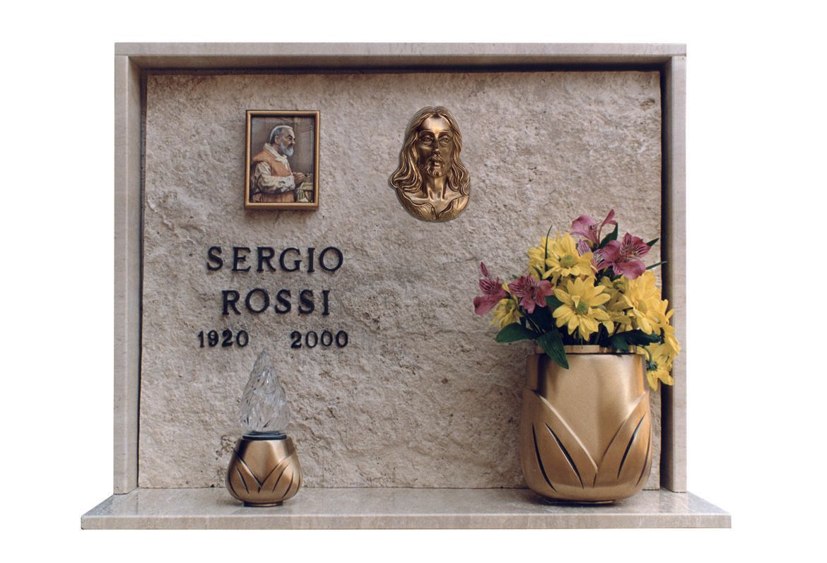 lapide in marmo decorato con vaso e lume