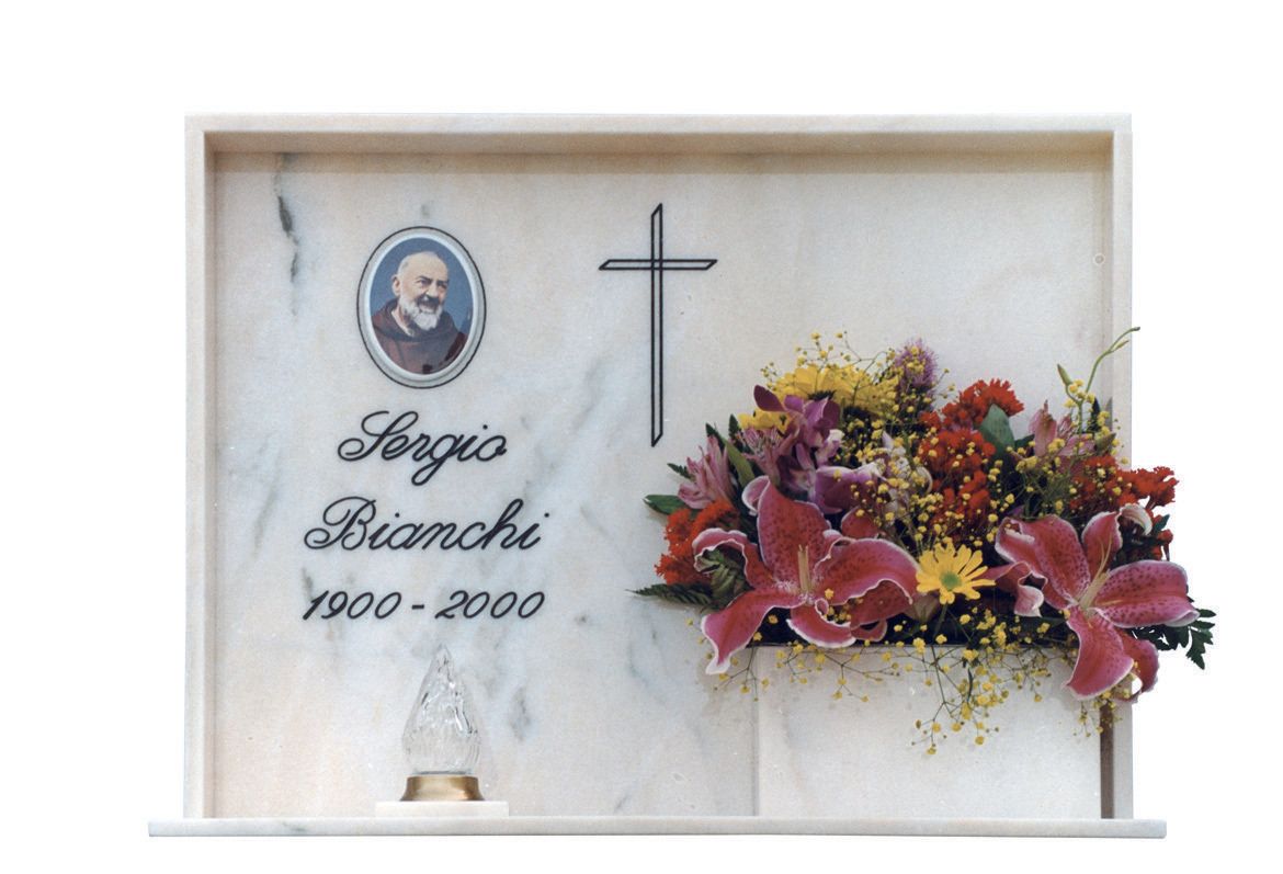 lapide commemorativa con luce e fiori