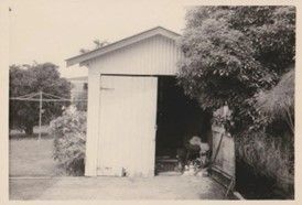 1970s B&W photo of a garage with one door open