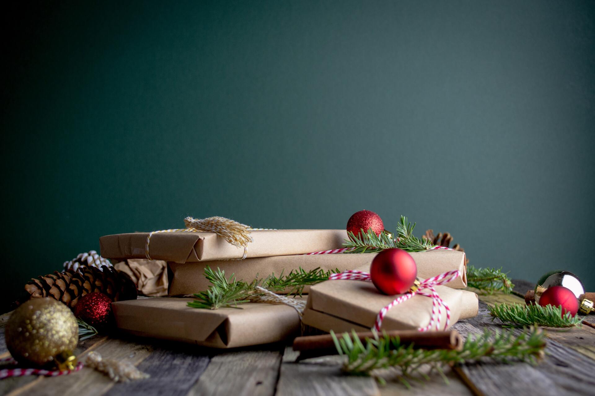 Christmas gifts in plain paper, surrounded by baubles and pine needles