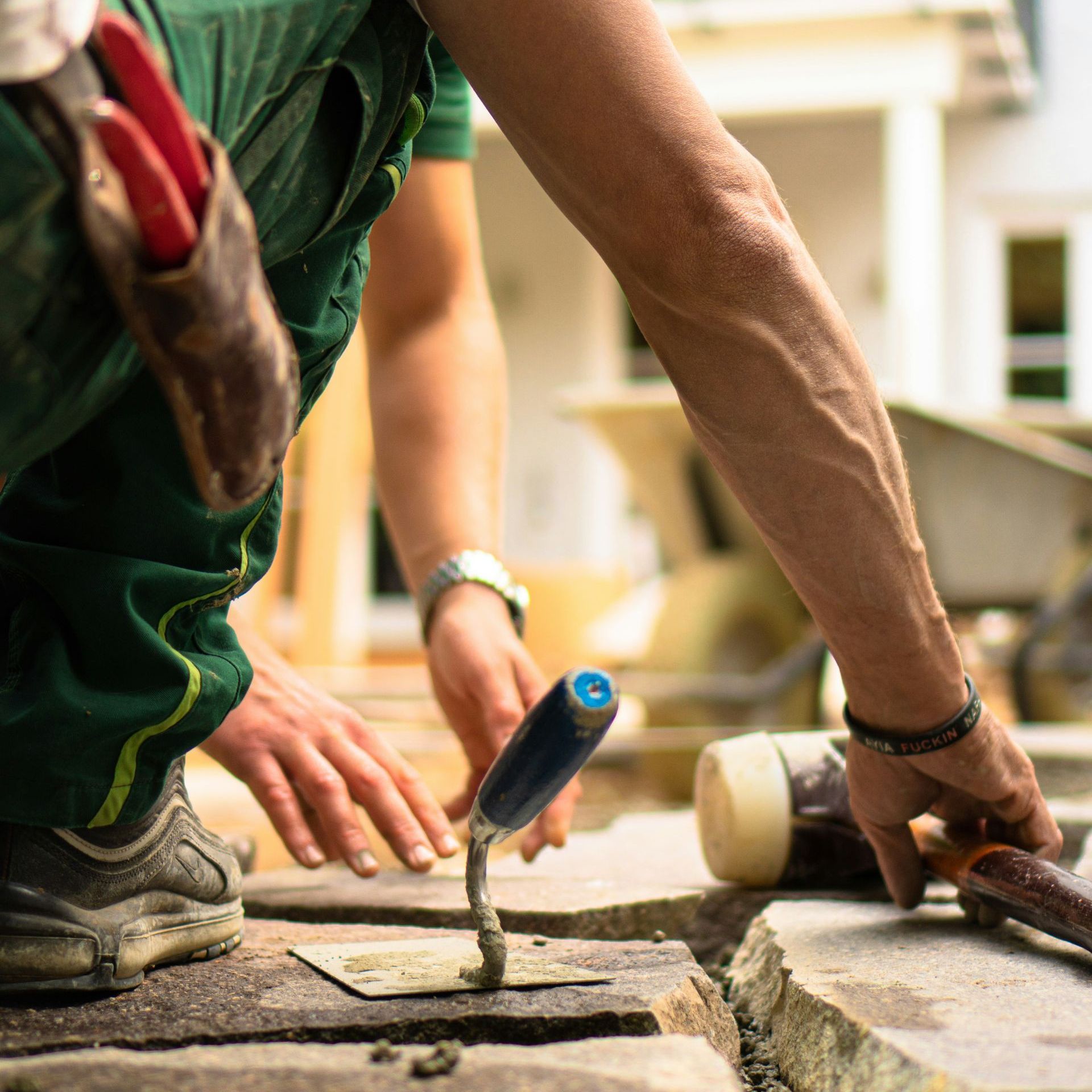 Workers hands as they lay paving stones