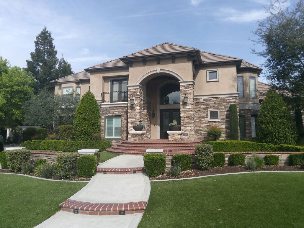 A large house with a brick walkway leading to it