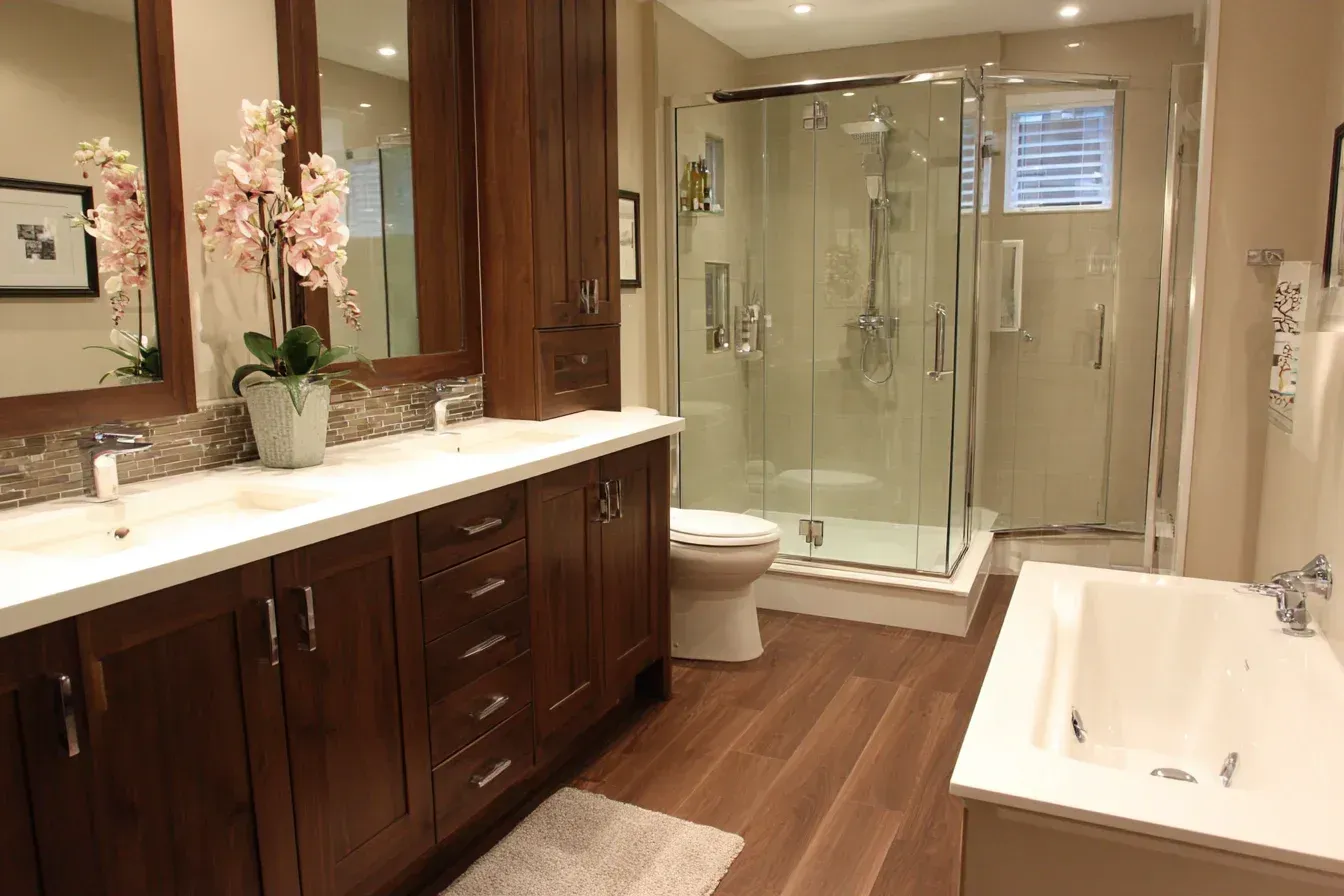 Bathroom with brown cabinets, double sinks, glass shower, and tub; wooden floors.